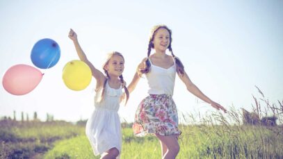 ninas-corriendo-globos-campo